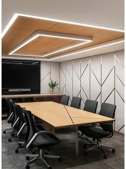 A meeting room in 'The Layered Office' showcases a consistent design language used across all floors. It features fabric paneling with stainless steel inlays and a custom Corian-finished table, with a TV concealed behind a back-painted glass panel.