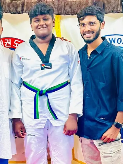 A student and his coaches after he earned his new belt.