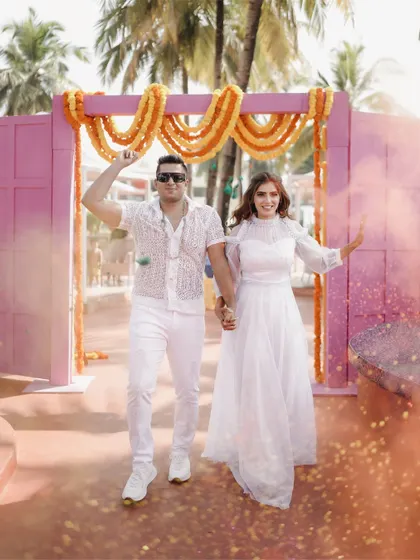 The couple's entry into their "Rang" party, dressed in white and ready to be covered in a rainbow of colors.