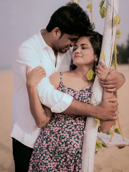 An intimate embrace by the beach swing. This pose is full of tenderness and shows the quiet connection between the couple.