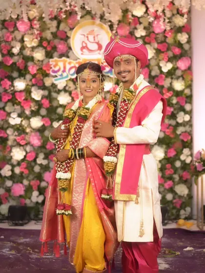A full-length shot of the couple, highlighting the beautiful drape of the bride's Nauvari and the groom's traditional kurta.