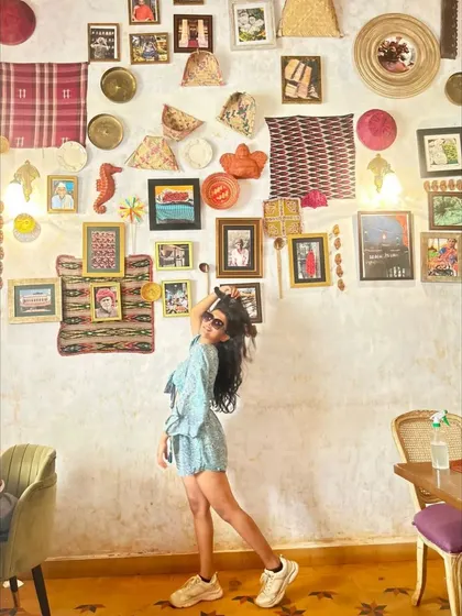 A playful pose against a colorful, art-filled wall in a Goan cafe. This image shows my fun personality and ability to interact with my environment.