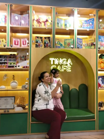 A mother and child pose in our cozy Tinga Cafe seating nook. It's a perfect spot for a quick photo and a break from the high-energy play.