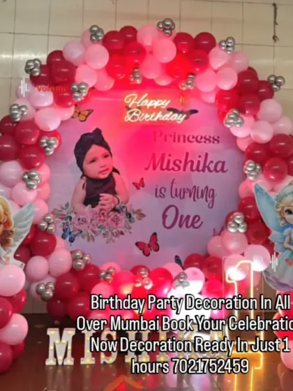 An angelic theme for a princess turning one. This red and pink decoration includes a custom backdrop with the baby's photo, cute angel wing cutouts, and a neon "Happy Birthday" sign.