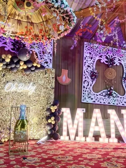 An elegant "Oh Baby" celebration with a gold shimmer wall and black balloon decor. The large marquee letters add a personalized touch.