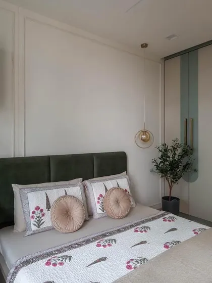 A beautiful transformation. This once-bare room is now a serene guest bedroom, featuring a soothing color palette of sage green and olive, with custom-designed wardrobes and a cozy study nook.