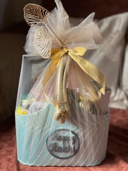 The blue fabric Rakhi basket beautifully wrapped in tulle with a gold ribbon, ready for gifting.