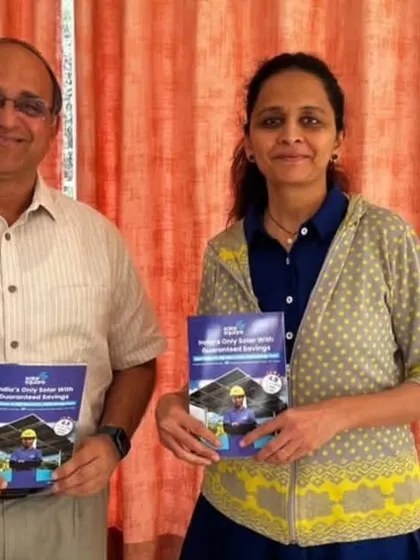 A couple proudly holds our solar guide. We are helping communities across India embrace a sustainable lifestyle.