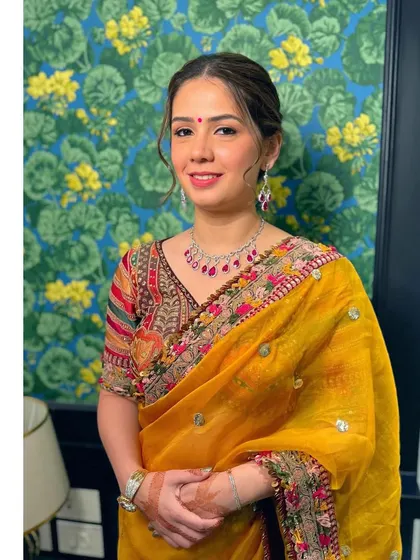 A portrait showing the full effect of the timeless saree look. The makeup is soft and pretty, with a small bindi to complete the traditional feel.