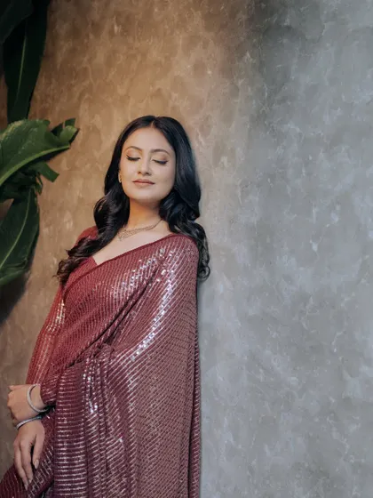 A serene and elegant portrait, with the bride leaning against a textured wall.