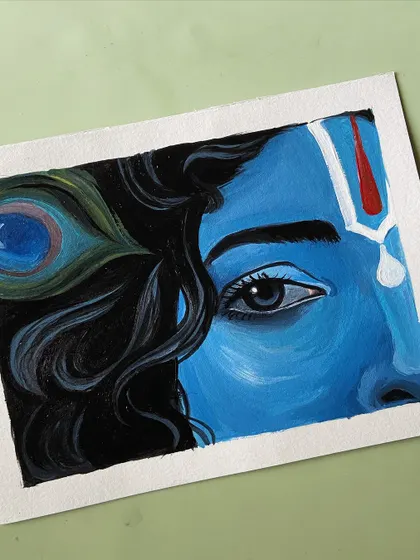 A close-up of a different Krishna painting, focusing on his eye and the peacock feather in his hair.