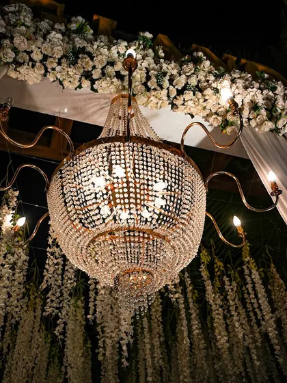 A close-up of a magnificent crystal chandelier. Lighting is key to setting the mood, and these grand chandeliers add a touch of timeless elegance and luxury to any event.