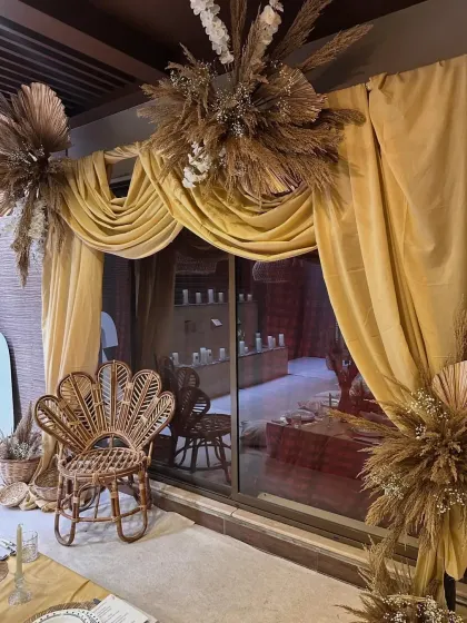 A detail shot of the elegant gold drapery and dried floral arrangements. These elements added a touch of luxury and texture to the boho-themed dinner party.