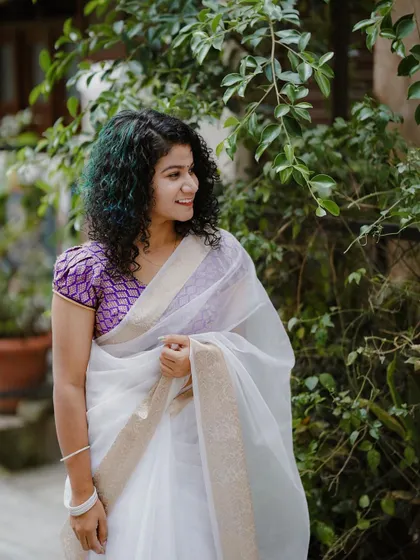 A lovely three-quarter shot of the model in her Onam attire. Her happy expression and the simple, natural background make this a perfect example of a festive portrait.