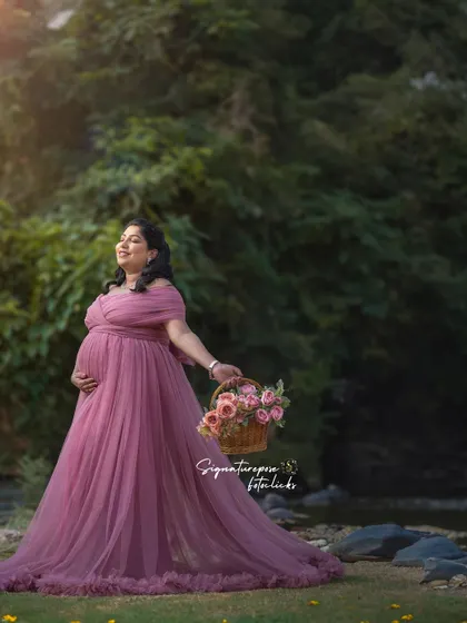 A soft, romantic outdoor portrait in a mauve gown, with the mother-to-be holding a basket of flowers.