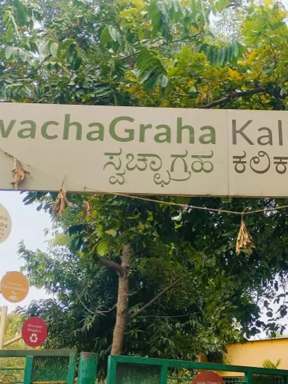 The entrance sign sits among trees at SwachaGraha Kalika Kendra, a view from our composting learning visit with Vasuki.