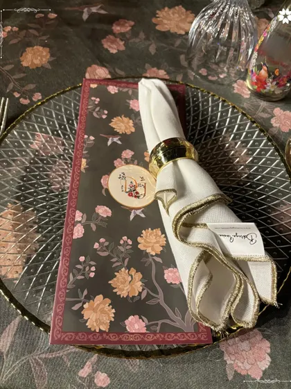 An elegant place setting from the Adani Sangeet. The intricate charger plate, custom menu, and floral motif create a sophisticated and cohesive look that speaks to the grandeur of the evening.
