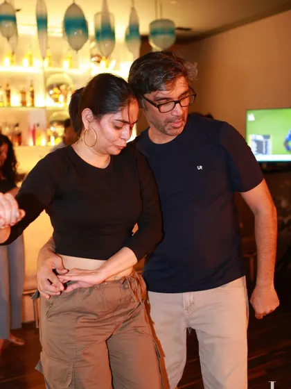 A couple in a close dance hold, concentrating on their steps. This image shows the technical side of social dancing in a relaxed club environment.