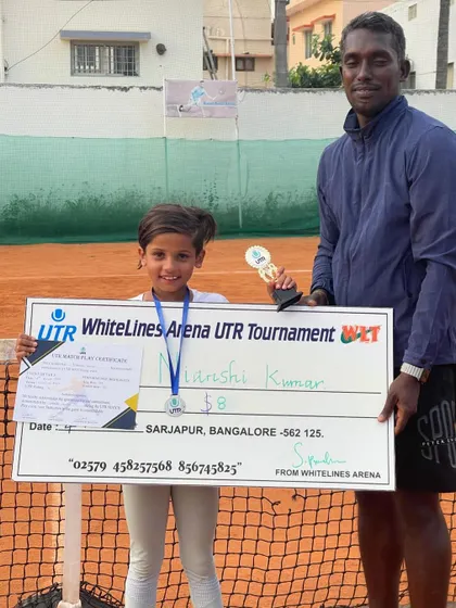 Nianshi Kumar with her coach and runner-up prize from the UTR green dot tournament. We believe in starting young and providing expert guidance from day one.