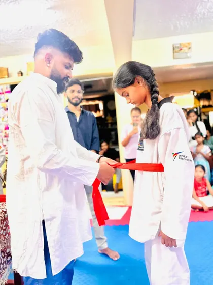Another student proudly receives her red belt.