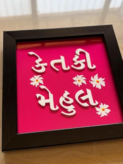 The full view of the Gujarati nameplate, showing the playful font and floral details.