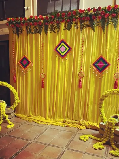 Even a simple haldi setup can be beautiful. Here, I used bright yellow drapes as the base and added colorful hanging tassels and marigold wreaths to create a festive and budget-friendly photo corner.