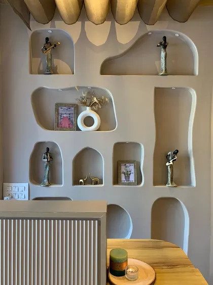 The decor in the studio is designed to create a calm and artistic atmosphere. These unique wall niches hold small art pieces that add to the overall aesthetic.
