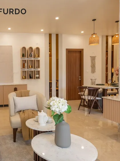 This view showcases the open-concept design, connecting the living room to the dining area in the background. We used a consistent color palette and materials like marble and wood to create a harmonious and flowing space.