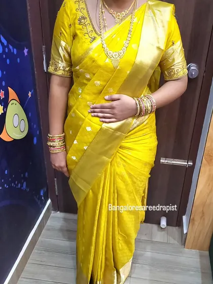 A full-length view of the gold saree drape. The body-fit style ensures a smart silhouette while maintaining a traditional feel appropriate for the event.