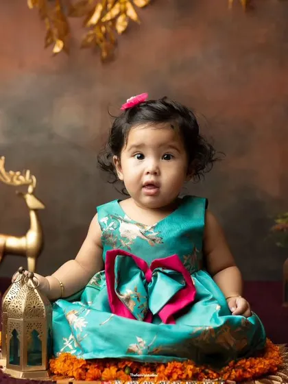A beautiful portrait from our Indian festive theme, with a baby girl in a lovely teal dress surrounded by traditional decor.