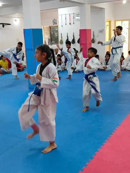 Students practicing their kicks in unison.