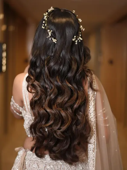 This Sangeet look features long, flowing waves with beautiful highlights, accented by a delicate, starry hair vine for a touch of sparkle.