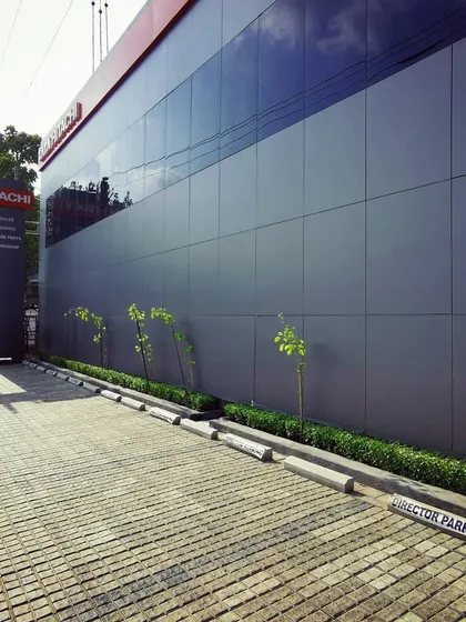 The building's exterior showing the rainscreen system and dedicated director parking with permeable pavers. This demonstrates our attention to both technical performance and practical site planning.