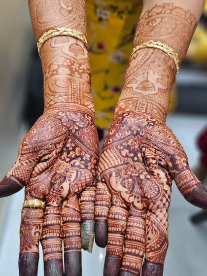 The final result: a deep, rich mahogany stain on a bridal mehendi. This showcases the quality of my organic henna and proper aftercare, with details like the jhumka (earring) motifs clearly visible.