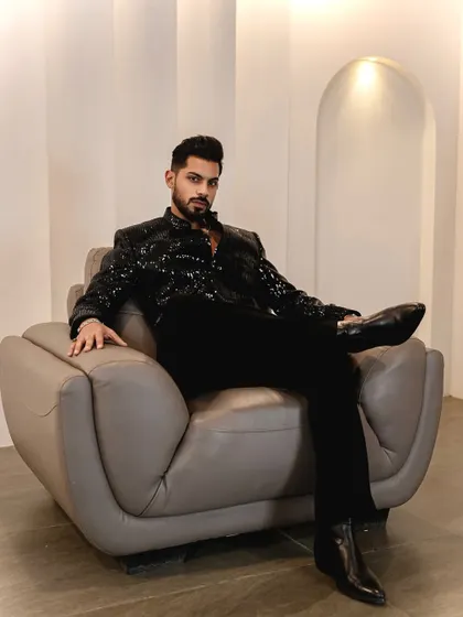 Relaxed yet sophisticated. Lounging in our black sequined jacket, this image shows that high fashion can also be comfortable. It's a perfect look for a stylish evening.