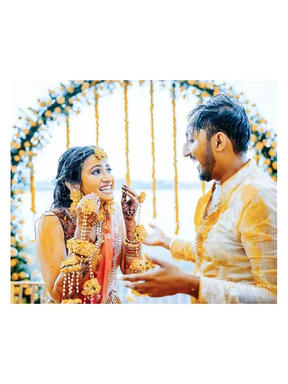 A happy, candid moment between the bride and groom during their Haldi ceremony at the scenic Moongate venue.