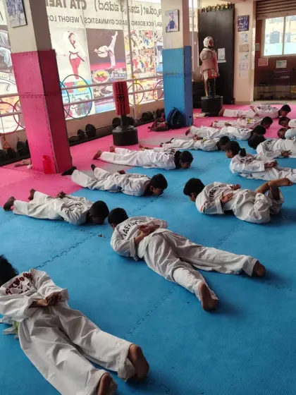 Students lie down for a resting pose after an intense workout session.