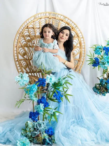 A wide shot showing the beautiful setup for a mommy-and-me session, with a stunning tulle gown and floral arrangements.