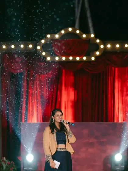 The stage is set for a show-stopping performance. With dramatic lighting and a classic red curtain backdrop, this Broadway-themed Sangeet stage was the perfect setting for the couple's first dance.