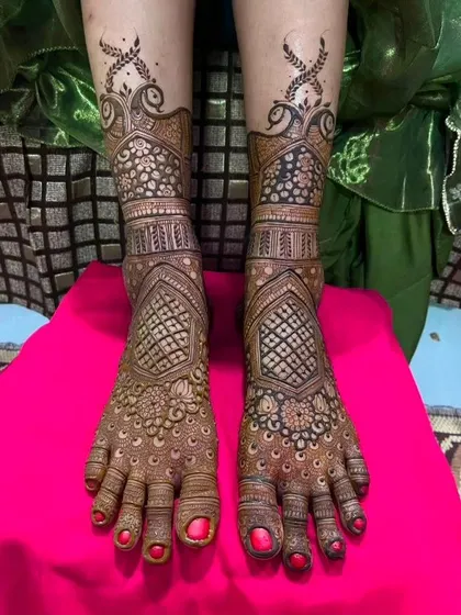 A dense and intricate foot design with beautiful peacock and jaali patterns, perfectly complementing a full bridal hand design.