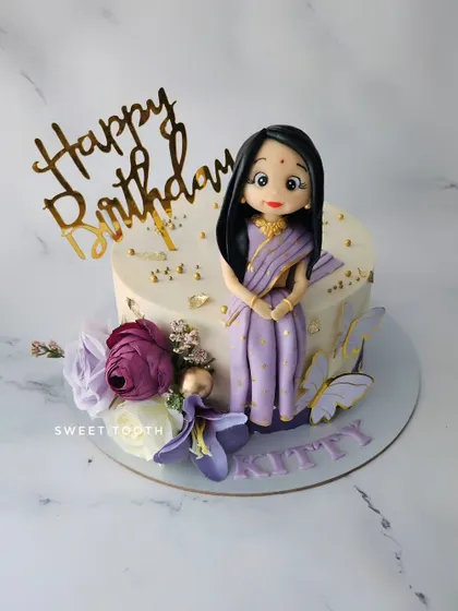A cake that screams "Grace over Grudges". This butterscotch cake features a beautiful figurine in a traditional saree, radiating elegance and strength.