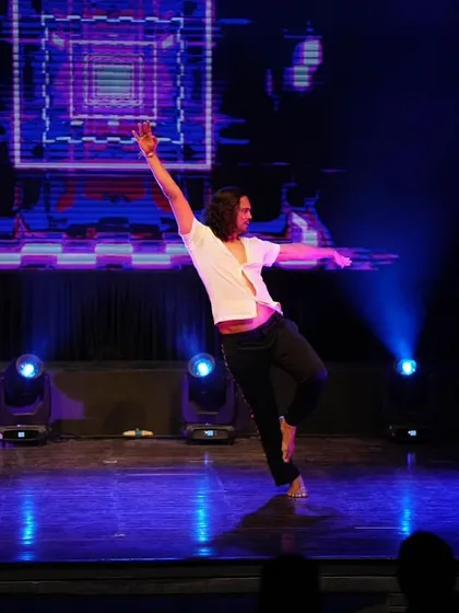 A fluid, graceful move across the stage during my solo piece. The blue lighting created a dramatic and mesmerizing atmosphere for this contemporary dance.