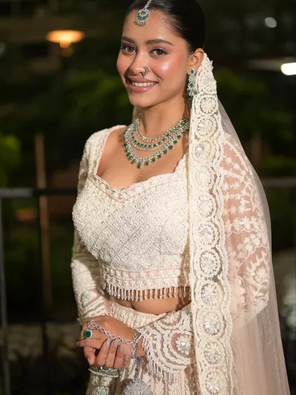 A full-length view of the bride. The clean makeup and sleek bun create a sophisticated and modern bridal look.