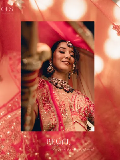 "Regal." A captivating shot of a bride under her red veil. The warm lighting and her confident smile make this a powerful and statement-making bridal portrait.