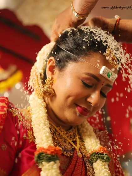 The bride being showered with rice and blessings. We capture this significant ritual with a focus on the bride's serene expression and the beauty of the moment.