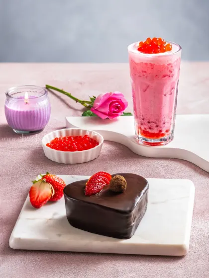 A Valentine's Day themed shot featuring a heart-shaped chocolate pastry and a strawberry bubble tea, creating a romantic mood.
