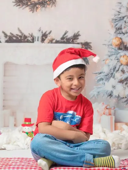 A collection of happy kids enjoying my two distinct Christmas setups: a bright, snowy winter scene and a warm, rustic brick fireplace.