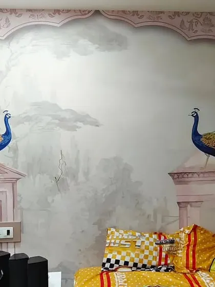 A beautiful bedroom mural featuring peacocks perched on pink Rajasthani architectural elements. This installation brings a grand, palatial feel to the room.