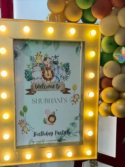 A personalized welcome sign is a must. For this jungle party, we framed the sign with marquee lights to make it a standout feature at the entrance.