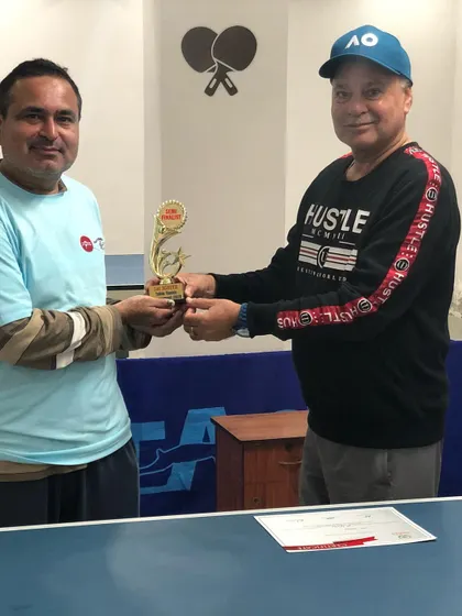A participant being awarded his trophy for securing a top position. We celebrate the spirit of competition and the hard work of every player who steps up to the table.